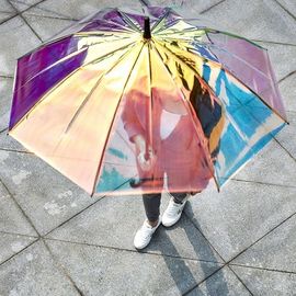 Kolorowy, opalizujący hologramowy przezroczysty parasol przeciwdeszczowy na deszczowy wietrzny dzień