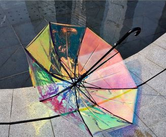 Kolorowy, opalizujący hologramowy przezroczysty parasol przeciwdeszczowy na deszczowy wietrzny dzień